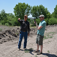 Jerry Woodrow explaining irrigation diversion near a push up dam to Rosdail. Photo Credits: Mary Harner